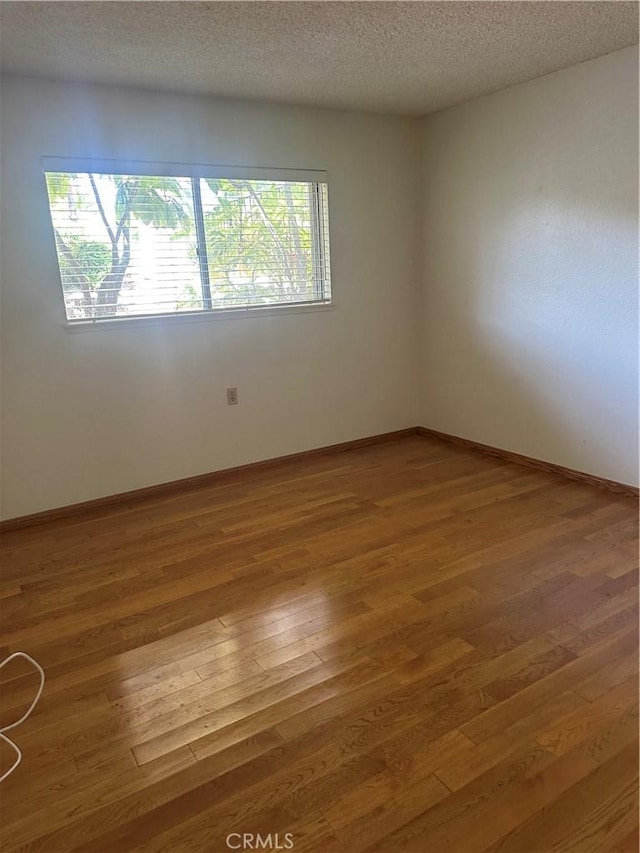 967 Calle Aragon Unit B, Laguna Woods, CA 92637 - spare room featuring wood finished floors and a textured ceiling
