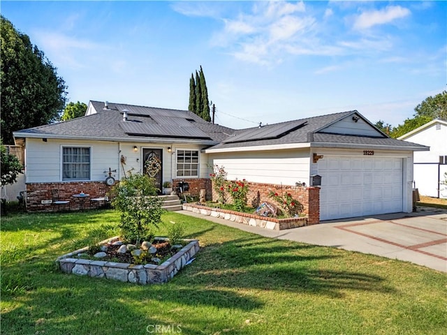 18229 Strathern St, Reseda, CA 91335 - view of front of house with brick siding, an attached garage, driveway, a front yard, and roof mounted solar panels