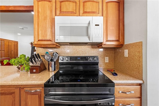 18229 Strathern St, Reseda, CA 91335 - kitchen featuring white microwave, black range with electric stovetop, light countertops, and tasteful backsplash
