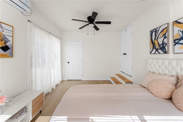 2998 N H St, San Bernardino, CA 92405 - bedroom with a wall unit AC, light wood-type flooring, and a ceiling fan