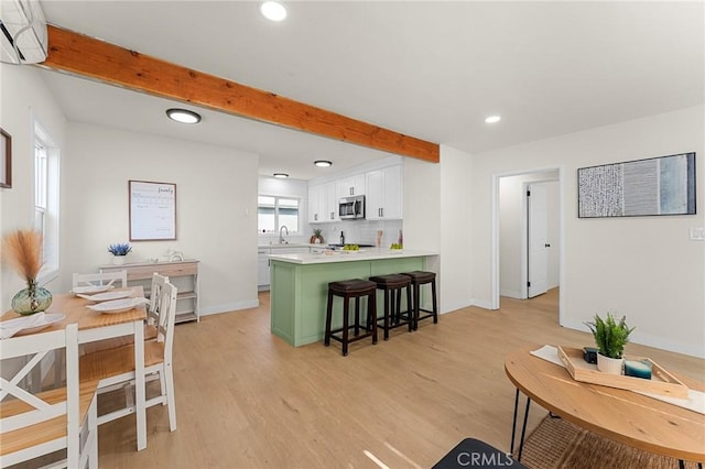 2998 N H St, San Bernardino, CA 92405 - living area featuring an AC wall unit, beam ceiling, light wood finished floors, and recessed lighting