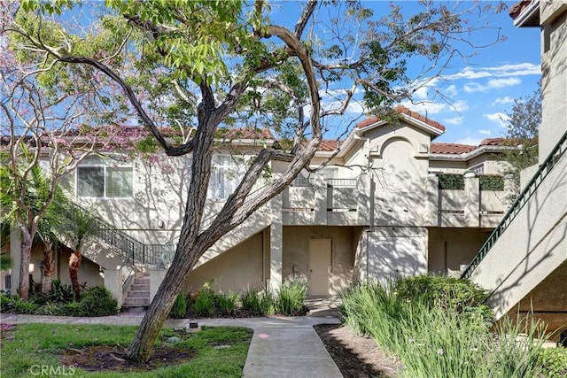 94 Cinnamon Teal, Aliso Viejo, CA 92656 - view of front of property featuring stucco siding, stairway, a balcony, and a tiled roof