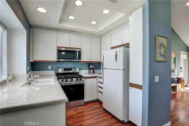 94 Cinnamon Teal, Aliso Viejo, CA 92656 - kitchen featuring stainless steel appliances, tile counters, dark wood-style floors, a tray ceiling, and recessed lighting