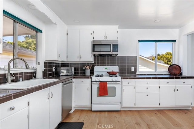 53 Rafael Way, San Luis Obispo, CA 93405 - kitchen with appliances with stainless steel finishes, tile counters, white cabinetry, backsplash, and light wood-style floors