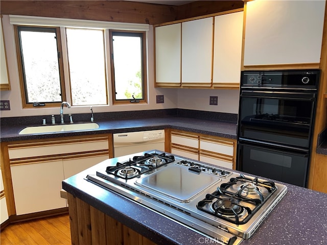 1608 Bradford Rd, Cambria, CA 93428 - kitchen with stovetop with downdraft, white dishwasher, light wood finished floors, and dark countertops