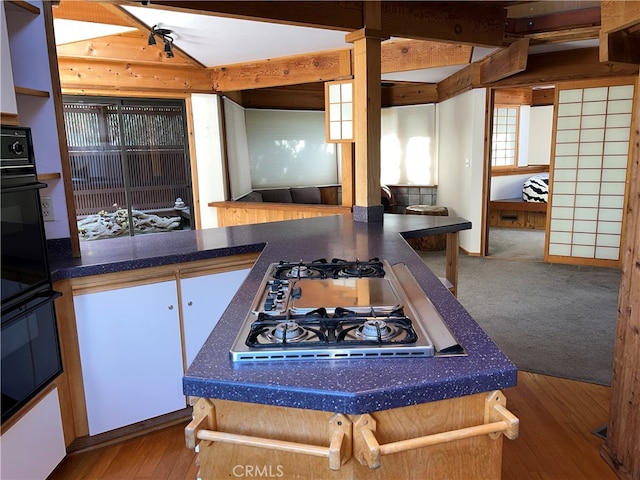 1608 Bradford Rd, Cambria, CA 93428 - kitchen with stainless steel gas stovetop, dark countertops, and wood finished floors