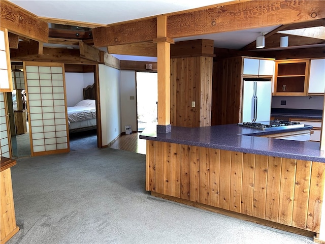 1608 Bradford Rd, Cambria, CA 93428 - kitchen featuring freestanding refrigerator, stainless steel gas stovetop, dark countertops, carpet, and wooden walls