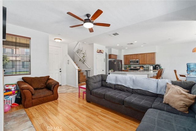 3381 Evening Mist Ln, Perris, CA 92571 - living room with stairs, light wood-style floors, and ceiling fan