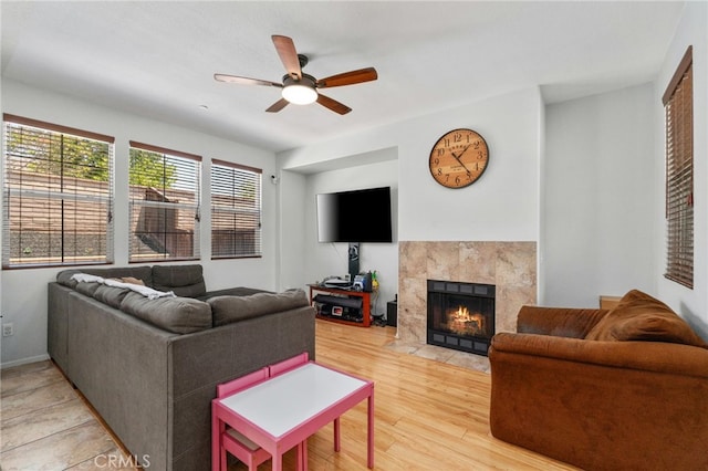 3381 Evening Mist Ln, Perris, CA 92571 - living area with ceiling fan, a tiled fireplace, and light wood-type flooring