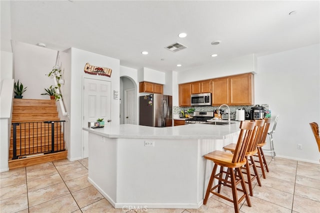 3381 Evening Mist Ln, Perris, CA 92571 - kitchen featuring appliances with stainless steel finishes, light tile patterned floors, light countertops, decorative backsplash, and recessed lighting