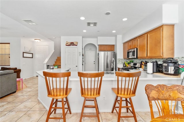 3381 Evening Mist Ln, Perris, CA 92571 - kitchen with appliances with stainless steel finishes, a peninsula, light countertops, tasteful backsplash, and recessed lighting