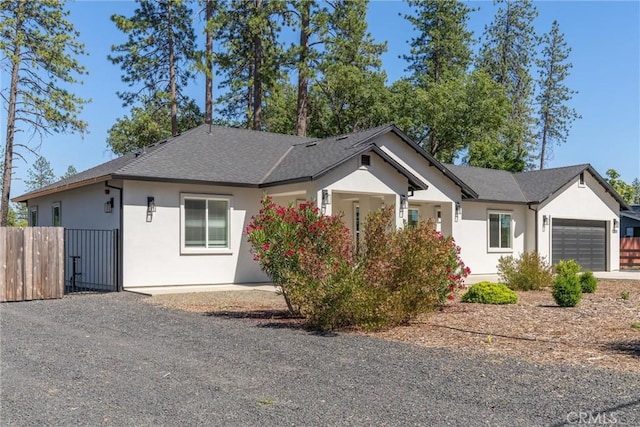 5790 Fickett Ln, Paradise, CA 95969 - view of front of home featuring an attached garage, stucco siding, driveway, roof with shingles, and a gate