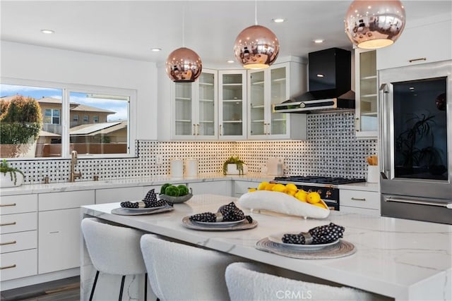 496 E 16th, Costa Mesa, CA 92627 - kitchen featuring wall chimney exhaust hood, refrigerator, white cabinets, decorative light fixtures, and light stone counters