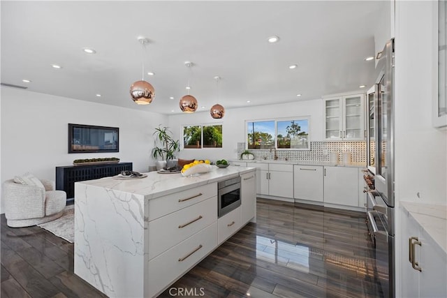 496 E 16th, Costa Mesa, CA 92627 - kitchen with recessed lighting, stainless steel microwave, white cabinetry, a kitchen island, and decorative backsplash