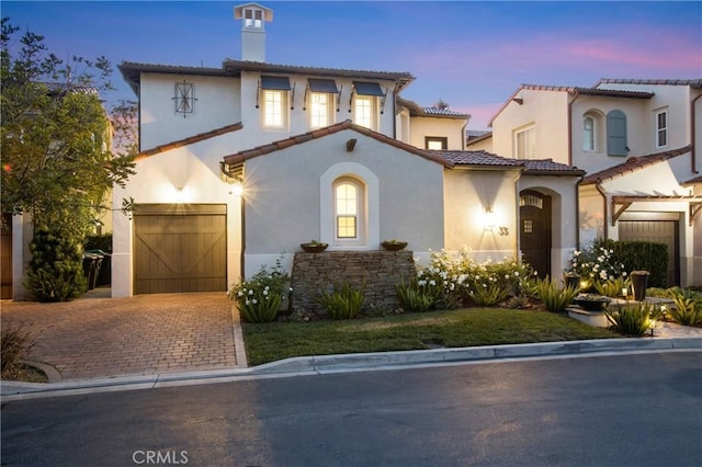 33 Renata, Newport Coast, CA 92657 - mediterranean / spanish-style house featuring a chimney, stucco siding, a garage, and a tile roof