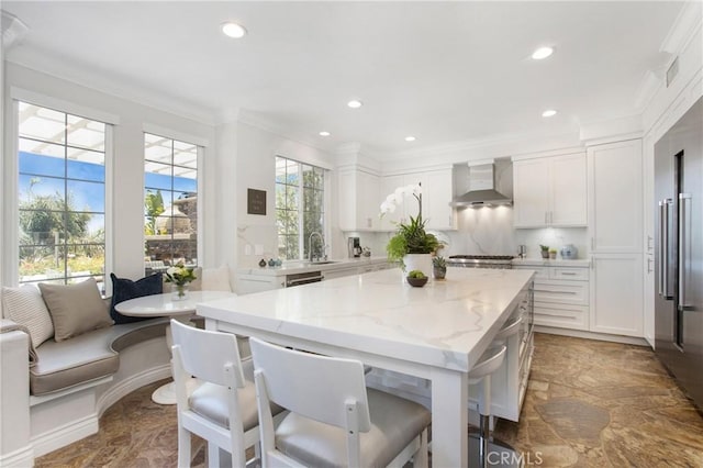 33 Renata, Newport Coast, CA 92657 - kitchen with wall chimney exhaust hood, white cabinets, ornamental molding, high quality fridge, and light stone countertops