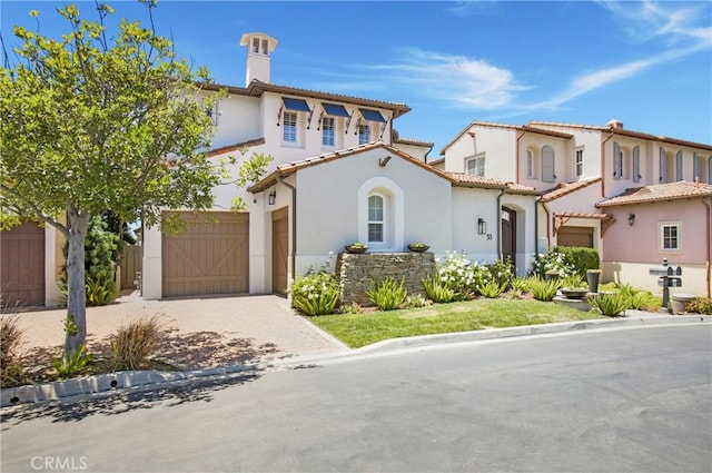 33 Renata, Newport Coast, CA 92657 - mediterranean / spanish home featuring an attached garage, a chimney, stucco siding, driveway, and a tile roof