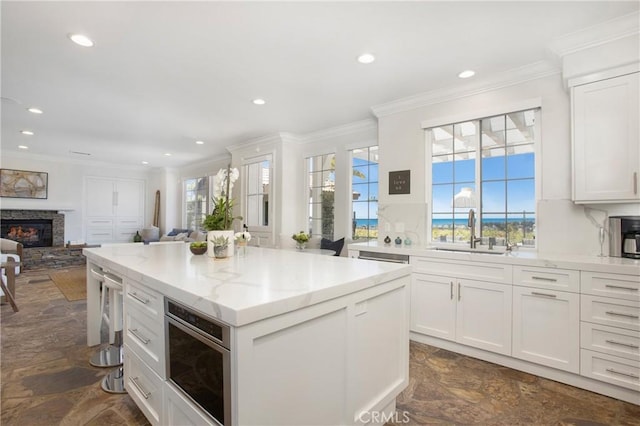 33 Renata, Newport Coast, CA 92657 - kitchen featuring dark stone finish flooring, open floor plan, recessed lighting, a kitchen island, and crown molding