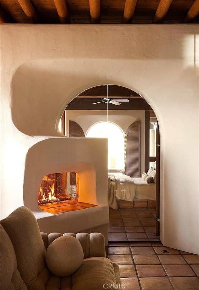 19623 Rd 211, Friant, CA 93626 - tiled living room featuring a wood ceiling with exposed beams, arched walkways, and ceiling fan