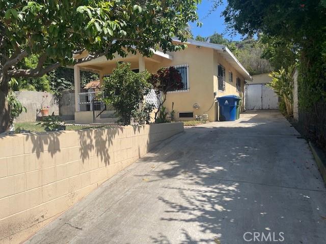 1153 Isabel St, Los Angeles, CA 90065 - view of side of home featuring a gate, stucco siding, and concrete driveway