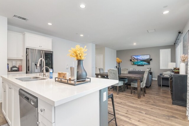 36961 Buccella Ln, Beaumont, CA 92223 - kitchen featuring appliances with stainless steel finishes, light wood-style flooring, recessed lighting, white cabinetry, and an island with sink