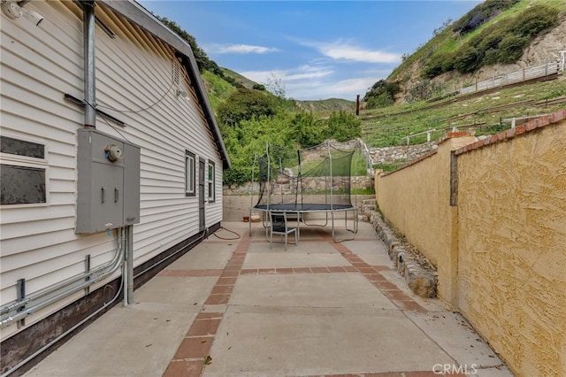 9707 Foothill Blvd, Sylmar, CA 91342 - fenced backyard with a trampoline, a patio, and a mountain view