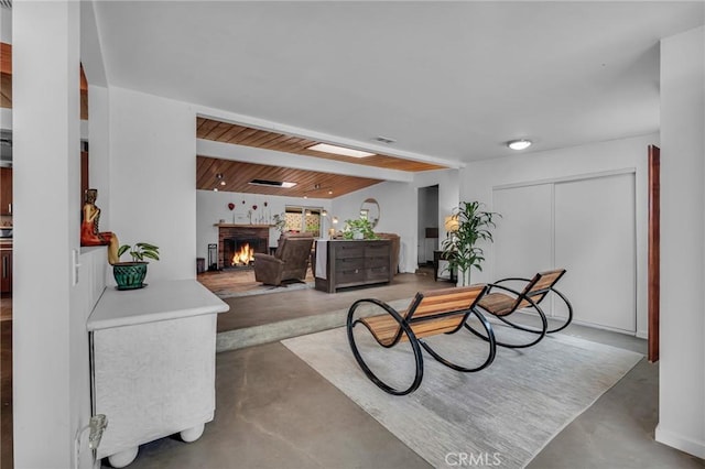 9707 Foothill Blvd, Sylmar, CA 91342 - living room with finished concrete floors, a warm lit fireplace, and beam ceiling