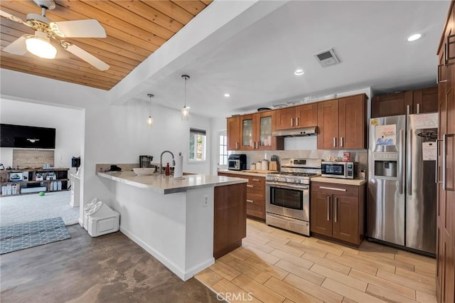 9707 Foothill Blvd, Sylmar, CA 91342 - kitchen with stainless steel appliances, under cabinet range hood, a peninsula, glass insert cabinets, and light countertops