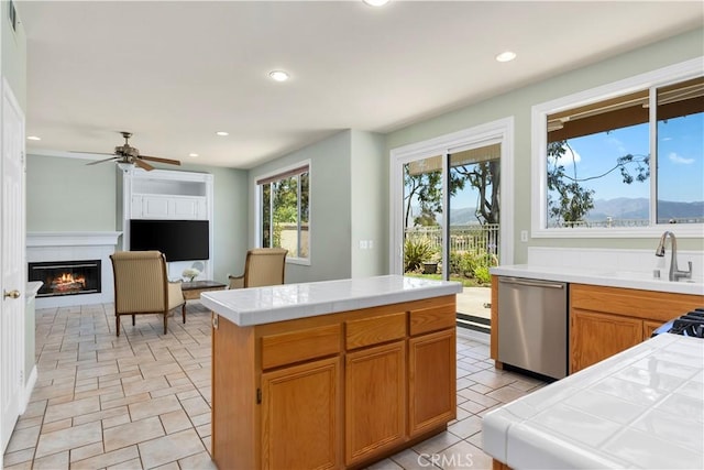 10 Via Berrendo, Rancho Santa Margarita, CA 92688 - kitchen with tile counters, stainless steel dishwasher, a tile fireplace, recessed lighting, and a ceiling fan