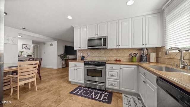 1652 Dewayne Ave, Camarillo, CA 93010 - kitchen with stainless steel appliances, white cabinets, decorative backsplash, recessed lighting, and light tile patterned floors