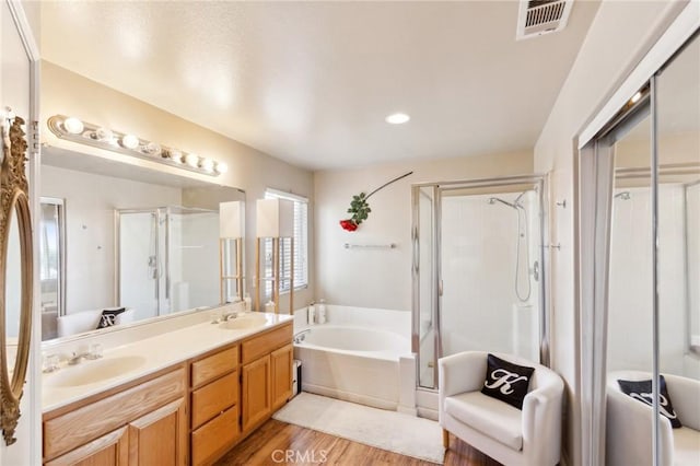 25880 Jumano Dr, Moreno Valley, CA 92551 - full bathroom featuring a garden tub, wood finished floors, double vanity, a stall shower, and recessed lighting
