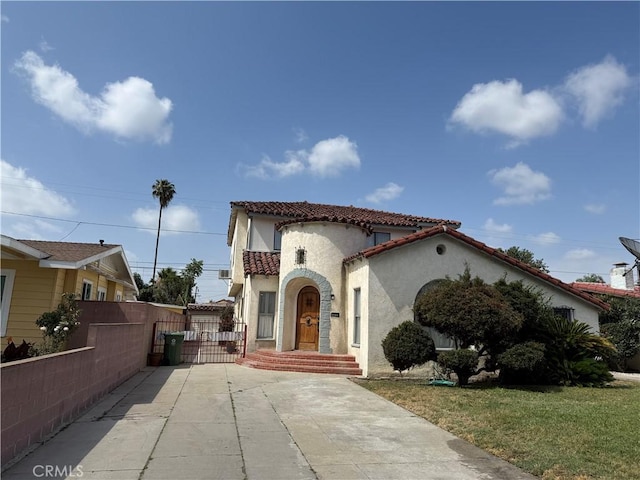2749 Hope St, Huntington Park, CA 90255 - mediterranean / spanish-style house featuring stucco siding, driveway, a tiled roof, and a gate