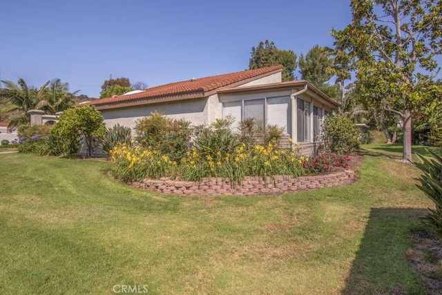 5521 Via La Mesa Unit C, Laguna Woods, CA 92637 - view of side of home featuring a lawn and stucco siding