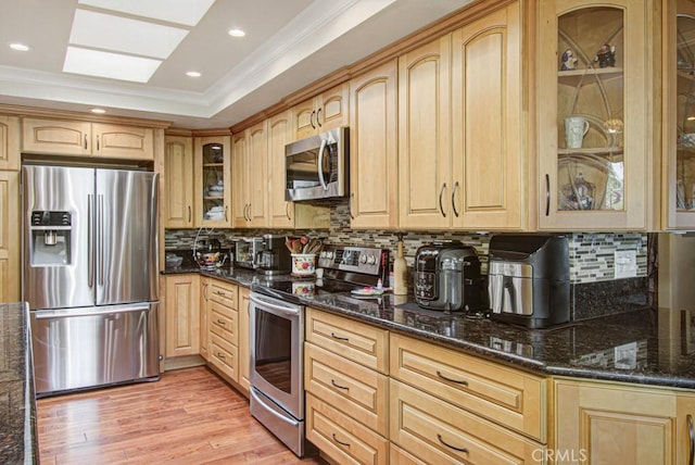 5521 Via La Mesa Unit C, Laguna Woods, CA 92637 - kitchen with stainless steel appliances, ornamental molding, dark stone countertops, decorative backsplash, and light wood-type flooring