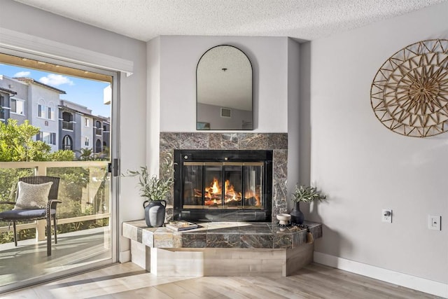 1508 Circa Del Lago Blvd Unit B204, San Marcos, CA 92078 - detailed view of wood finished floors, a textured ceiling, and a fireplace