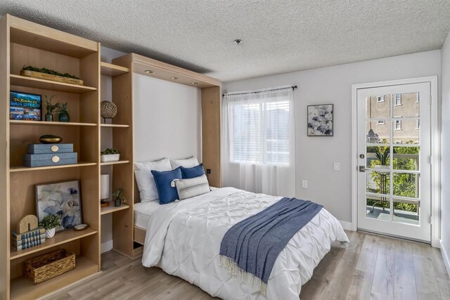 1508 Circa Del Lago Blvd Unit B204, San Marcos, CA 92078 - bedroom with access to outside, wood finished floors, and a textured ceiling