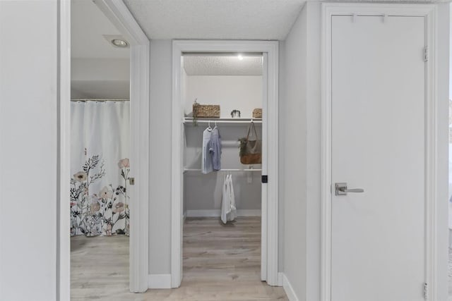 1508 Circa Del Lago Blvd Unit B204, San Marcos, CA 92078 - hallway featuring a textured ceiling and light wood finished floors