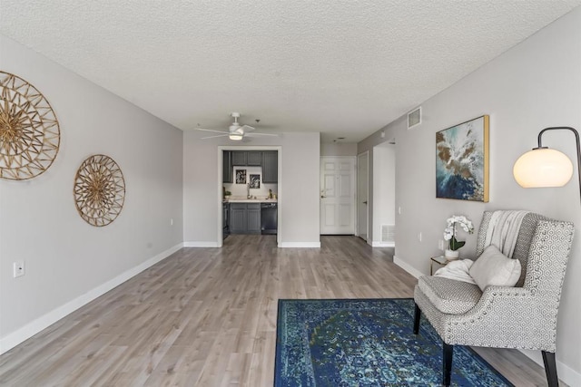 1508 Circa Del Lago Blvd Unit B204, San Marcos, CA 92078 - sitting room with light wood-style floors, a ceiling fan, and a textured ceiling