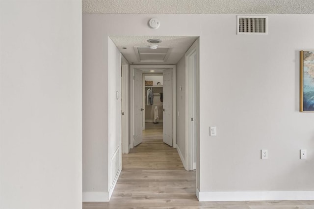 1508 Circa Del Lago Blvd Unit B204, San Marcos, CA 92078 - hall featuring light wood-style flooring, attic access, and a textured ceiling