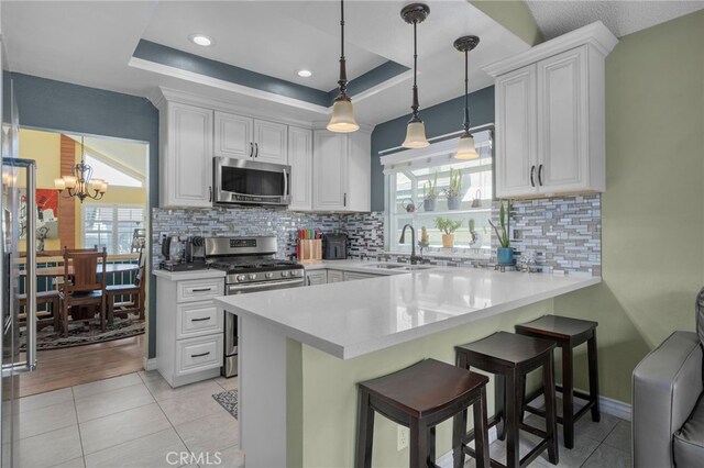 339 W Dawson Ct, Glendora, CA 91740 - kitchen with appliances with stainless steel finishes, white cabinets, a peninsula, light countertops, and a breakfast bar