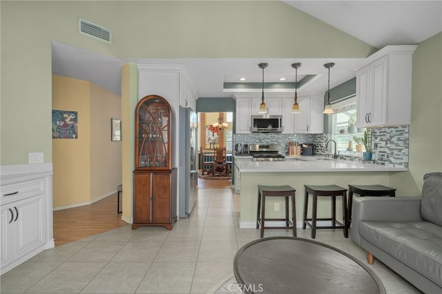 339 W Dawson Ct, Glendora, CA 91740 - kitchen with appliances with stainless steel finishes, tasteful backsplash, a peninsula, white cabinetry, and light countertops