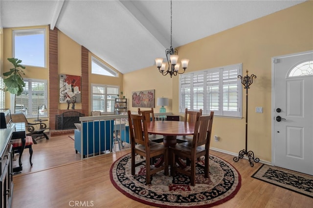 339 W Dawson Ct, Glendora, CA 91740 - dining area with high vaulted ceiling, beamed ceiling, wood finished floors, a chandelier, and a brick fireplace