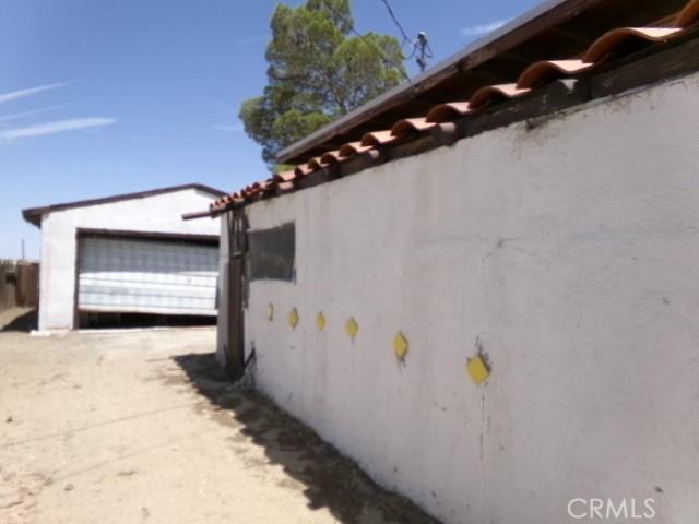34915 Cedar Rd, Barstow, CA 92311 - view of side of home featuring an outdoor structure, stucco siding, and a garage
