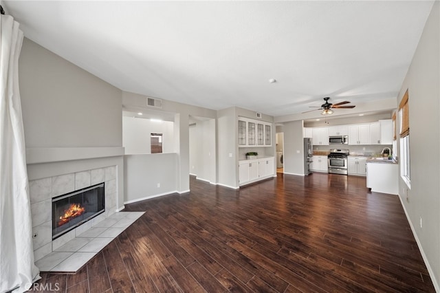 45114 Via Quivera, Temecula, CA 92592 - unfurnished living room featuring ceiling fan, a tiled fireplace, and dark wood-type flooring