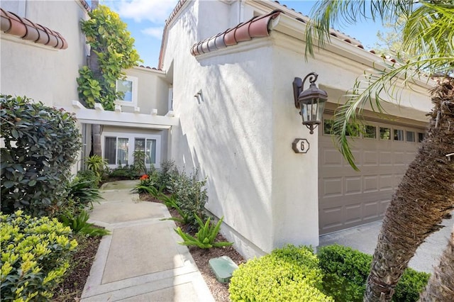 6 Baristo Unit 39, Irvine, CA 92612 - view of home's exterior featuring stucco siding, a tiled roof, and a garage
