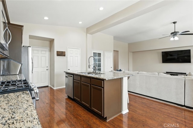 31969 Frontier Manor St, Menifee, CA 92584 - kitchen featuring stainless steel appliances, light stone counters, dark wood-style flooring, dark brown cabinetry, and ceiling fan
