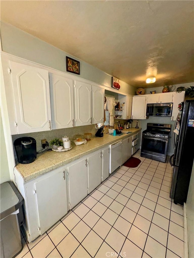 9778 Sharon Ave, Riverside, CA 92503 - kitchen with stainless steel appliances, light countertops, white cabinets, and light tile patterned floors