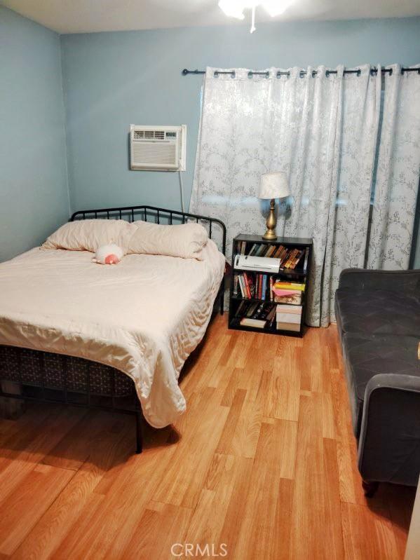 9778 Sharon Ave, Riverside, CA 92503 - bedroom with wood finished floors and an AC wall unit