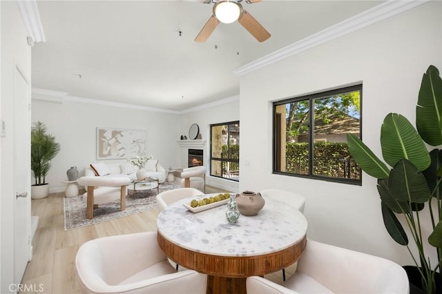 222 S Catalina Ave Unit 8, Pasadena, CA 91106 - dining room featuring plenty of natural light, ceiling fan, light wood-type flooring, a warm lit fireplace, and crown molding