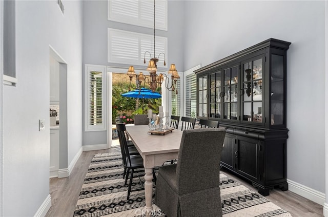 611 Del Dios, San Clemente, CA 92672 - dining space featuring a chandelier, light wood-style flooring, and a high ceiling